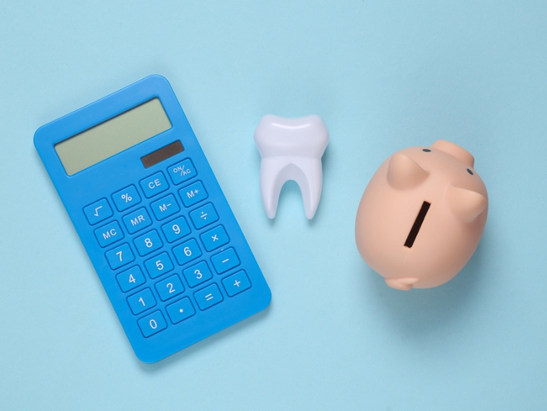 An image of a calculator, tooth, and a piggy bank.