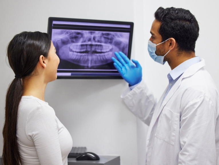 Two dentists use a screen display.