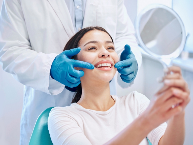 A woman at the dentist smiles happily